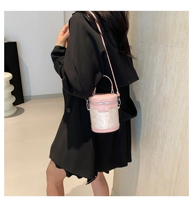 Detailed shot of pink cylindrical bucket bag with embroidery and silver hardware