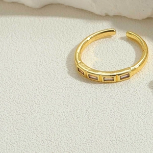 Macro detail of gold adjustable ring featuring four baguette-cut lavender gemstones