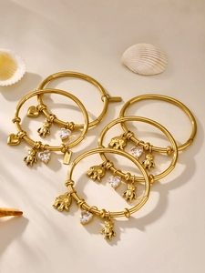 Detailed view of gold plated stainless steel bracelets with elephant and bear charms