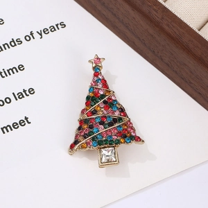 Golden Christmas tree brooch with colorful rhinestones on a white card display