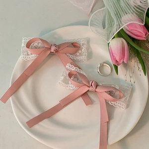 Detail of pink ribbon bow hair clips with delicate white lace base on a platter