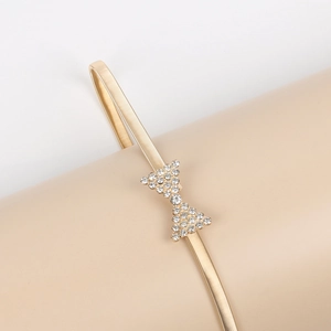 Détail de la ceinture dorée élastique à ressort avec boucle nœud en strass brillant