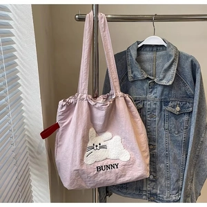 Pink canvas tote bag featuring 3D bunny embroidery and a secure drawstring closure