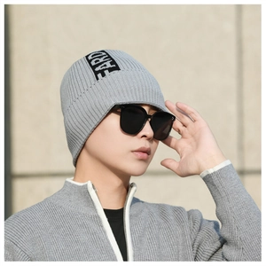 Detail of light grey ribbed knit beanie with white EARTH letter print on the side