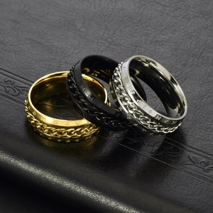 Three rotatable chain rings in gold, black, and silver on a black leather background