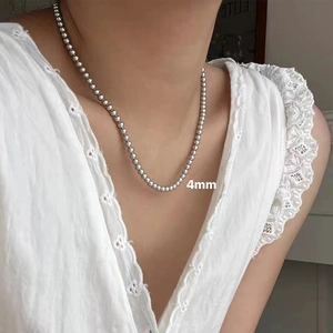 Close-up of 4mm silver bead necklace on model highlighting minimalist French retro style
