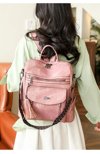 Detail of pink PU leather backpack featuring tassel accents and stylish patterned straps