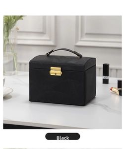 Detail of black PU leather jewelry box featuring gold metal lock on marble surface