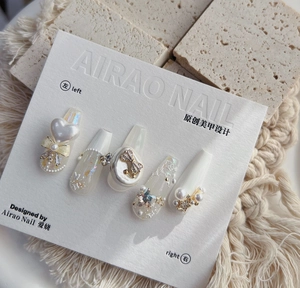 Detail of 5D embossed nail art stickers with pearls, bows, and sequins in pearly white