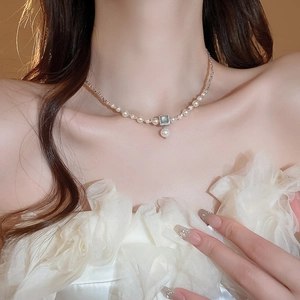 Detail of French style pearl necklace with square blue gemstone and teardrop pendant