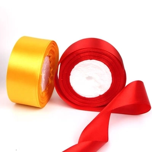 Detail of 4cm yellow and red satin ribbons on foam spools for DIY gift wrapping