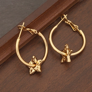 Minimalistische goldene Stern-Creolen auf einem dunklen strukturierten Holzhintergrund