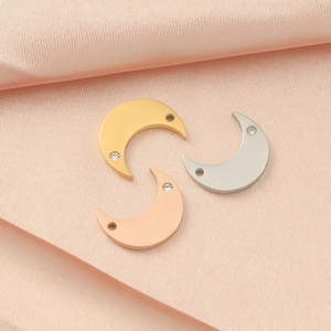 Mirror polished moon charms in gold, silver, and rose gold with rhinestones on pink silk