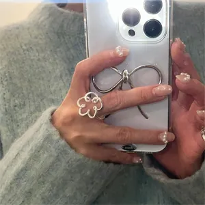 Detail of S925 sterling silver flower ring with smiley face cutout worn on finger