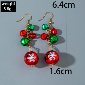 Detail of Christmas earrings featuring red and green bells with white snowflake patterns