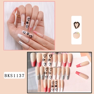 Detailed close-up of long coffin press-on nails with pink French tips and heart accents