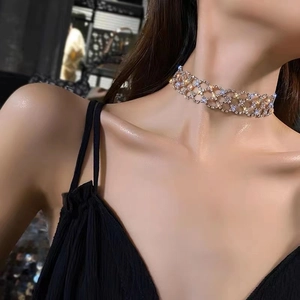 Nahaufnahme einer goldenen Strass-Halskette mit Gittermuster bei einem Frauenmodell