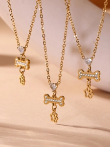 Detail van drie gouden kettingen met hartstenen, botvormige hangers en pootafdrukken