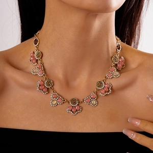 Close-up of vintage flower necklace with pink gemstones and rhinestones on neck