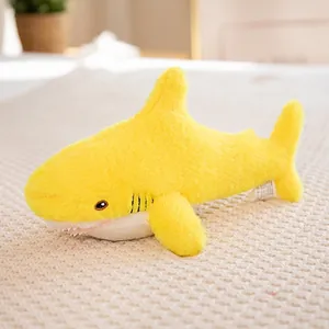 Soft yellow shark plush toy with white belly and embroidery eyes on knit background