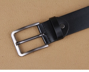 Nahaufnahme von schwarzem Ledergürtel mit eckiger Metallschnalle und Nahtdetails