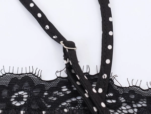 Close-up of adjustable strap and delicate black lace trim on polka dot top