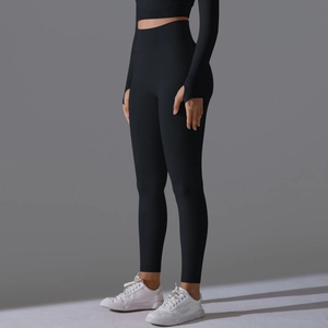 Detail view of black high waist yoga leggings and long sleeve top with functional thumb holes