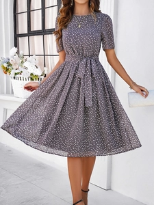 Détail d'une robe trapèze grise à pois avec ceinture nouée et texture en mousseline