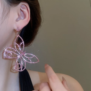Close-up of pink butterfly earring with sparkling crystals on female model