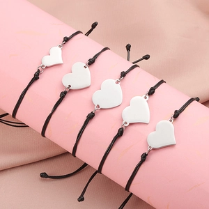 5-piece set of woven rope bracelets with mirror-finish heart pendants on a pink stand