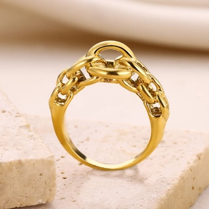 Detailed macro view of gold chain-link ring texture on aesthetic stone background