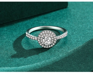 Detailed close-up of a halo s925 silver ring with a round center diamond on green velvet