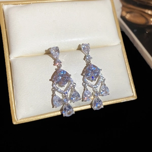 Macro shot of silver drop earrings with cushion and pear-cut cubic zirconia crystals
