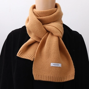 Detail of camel knitted scarf with soft thick texture and white FEIDING woven label