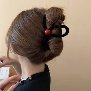 Elegant red bead and black flocked large hair claw clip worn on braided hair