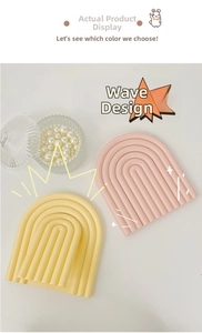 Detail of pink and yellow wavy arched decorative mirrors with a matte textured finish