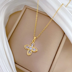 Detail of clover pendant necklace with clear cubic zirconia stones in a gold finish