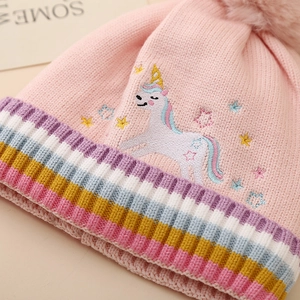 Détail du bonnet tricoté rose pour fille avec broderie licorne et pompon doux