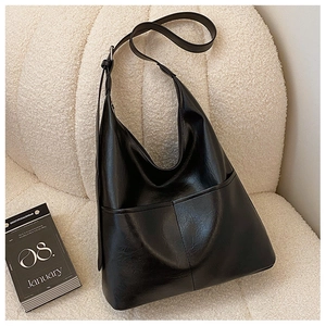 Vue détaillée du grand sac cabas noir en similicuir sur une texture polaire blanche