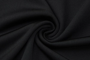 Macro view showing the spiral texture and knit pattern of the black polyester dress fabric