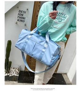 Close-up of a light blue large capacity travel bag with handles and adjustable shoulder strap