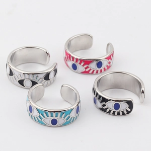 Flat lay of colorful enamel evil eye open rings in black, pink, blue, and white colors