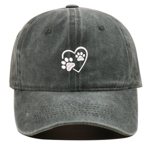 Detailed close-up of white heart and dog paw embroidery on washed dark grey baseball cap