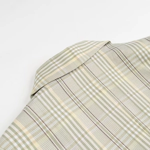 Close-up of the green plaid blazer neckline showing fabric texture and stitching details