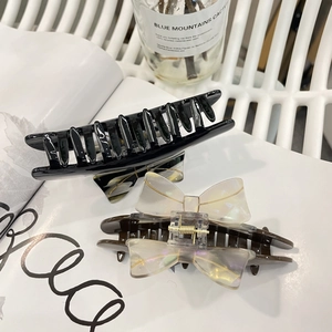 Detail of vintage French acetate hair claws with a shimmering colorful bow accent