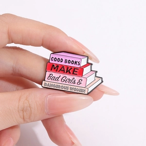 Pin's en émail en forme de pile de livres roses et rouges avec texte littéraire