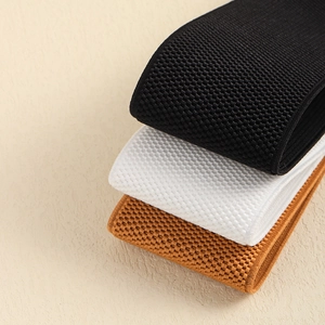 Detail of wide elastic waist belts with waffle knit texture in black, white and brown