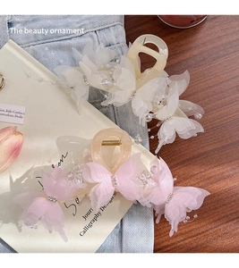 Detail of large butterfly hair claw clip with lace wings and pearl embellishments