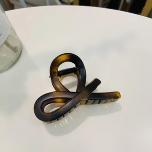 Detailed view of tortoiseshell hair claw clip with stylish twist design and durable spring