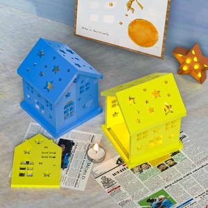 Kerzenhalter und Nachtlicht in Sternhaus-Form aus blau und gelb lackiertem Holzmaterial